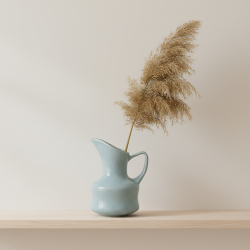Ceramic pitcher vase styled with pampas grass on a Scandinavian shelf