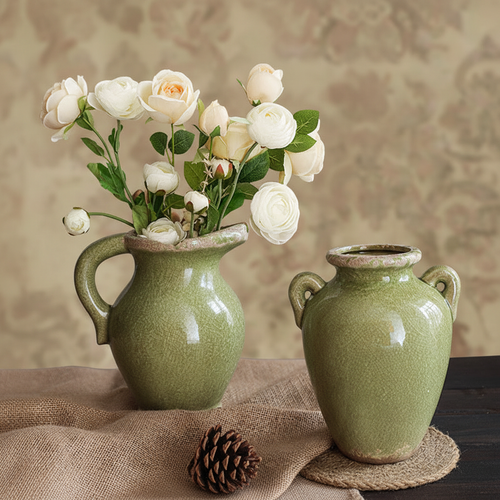 Sage green pitcher vase with white roses on rustic linen tablecloth